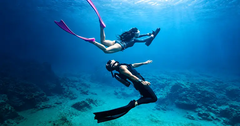 Divers exploring underwater with a KESZING underwater scooter
