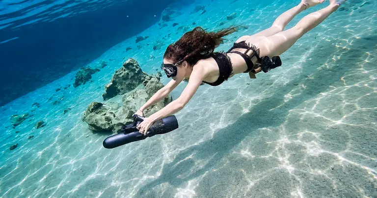 Diver using a KESZING underwater scooter in clear water