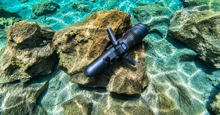 KESZING underwater scooter displayed on rocks underwater