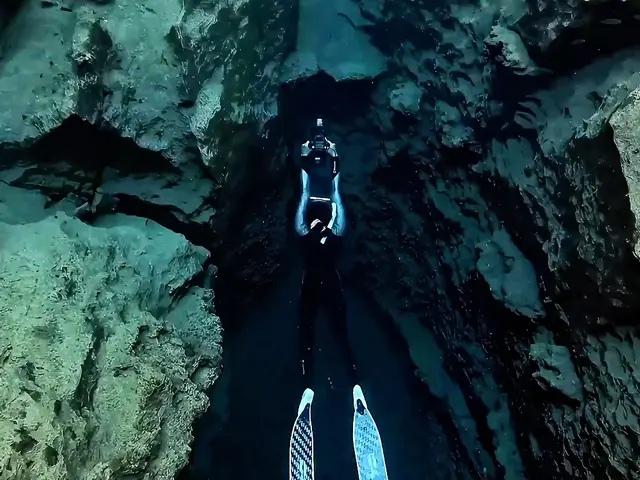 Diver exploring an underwater rocky passage with the KESZING LXHD 6-1